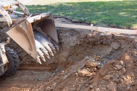 Small Bulldozer Digging In Yard For Pool Installation